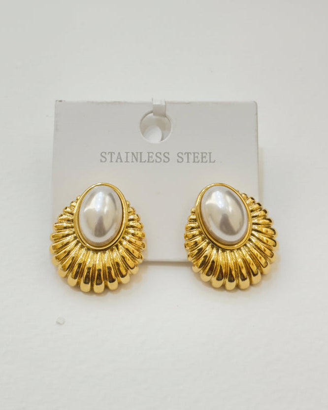 Gold earrings with pearl-like centers on a white background