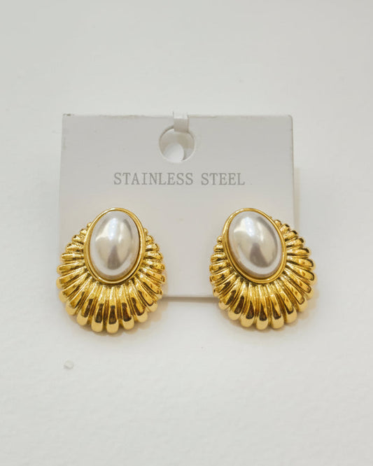 Gold earrings with pearl-like centers on a white background